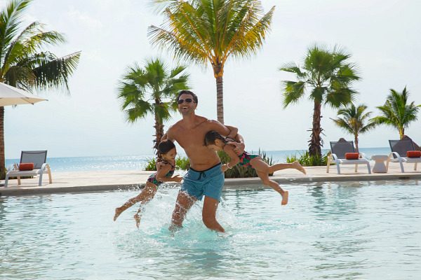 Father and daughters in pool